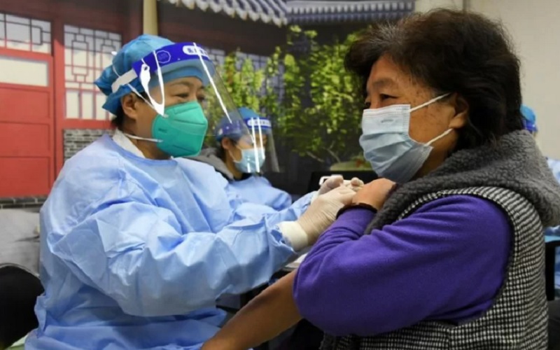 Seorang tenaga kesehatan memberikan suntikan penguat (booster) vaksin COVID-19 kepada warga setempat di sebuah lokasi vaksinasi sementara di Beijing, China pada 29 November 2021./Antra-Xinhua