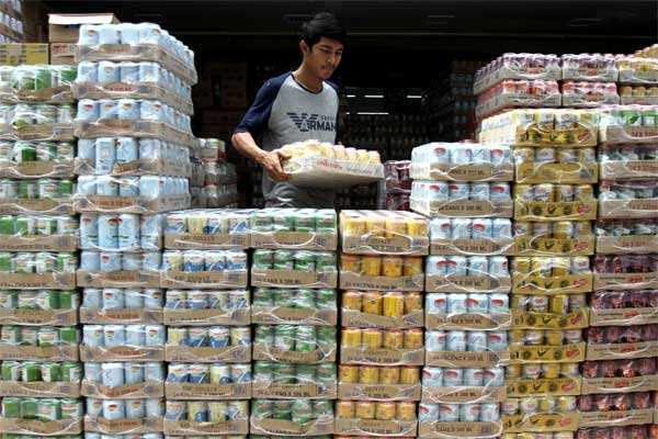 Pekerja menyusun aneka jenis minuman kaleng di salah satu grosir penjual makanan dan minuman kemasan di Pekanbaru, Riau, Senin (12/6)./Antara-Rony Muharrman