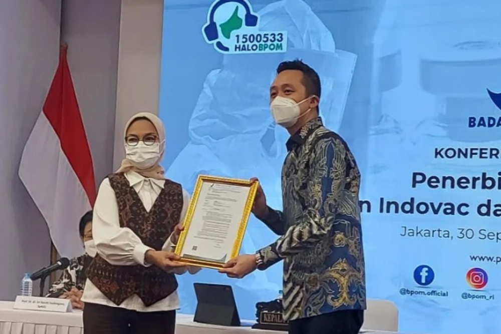 Kepala BPOM RI Penny K Lukito (kiri) menyerahkan sertifikat Izin Penggunaan Darurat (EUA) Vaksin AWcorna produksi PT Etana kepada Dirut PT Etana Nathan Tirtana (kanan) di Gedung BPOM RI, Jakarta, Jumat (30/9/2022)./Antara
