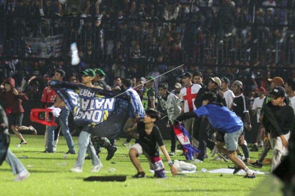Suporter Arema FC memasuki lapangan setelah tim yang didukungnya kalah dari Persebaya dalam pertandingan sepak bola BRI Liga 1 di Stadion Kanjuruhan, Malang, Sabtu (1/10/2022). Sebanyak 127 orang dilaporkan meninggal dunia dalam kerusuhan tersebut./Antara-Ari Bowo Sucipto.