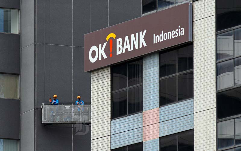 Pekerja melakukan perawatan gedung di dekat logo Bank Oke Indonesia di Jakarta, Jumat (12/11/2021). Bisnis/Arief Hermawan P