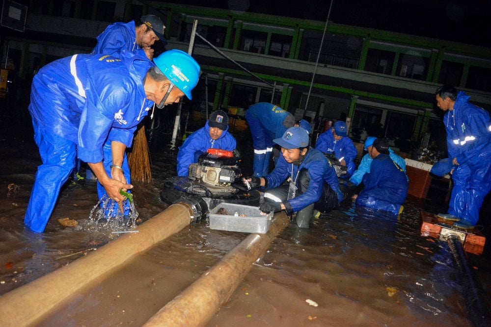Sejumlah petugas Suku Dinas Sumber Daya Air Jakarta Selatan penyedotan air yang menggenangi MTsN 19 Jakarta di Pondok Labu, Jakarta, Kamis (6/10/2022). Sebanyak tiga siswa meninggal tertimpa tembok yang roboh akibat terjangan banjir yang menggenangi sekolah tersebut. /Antara