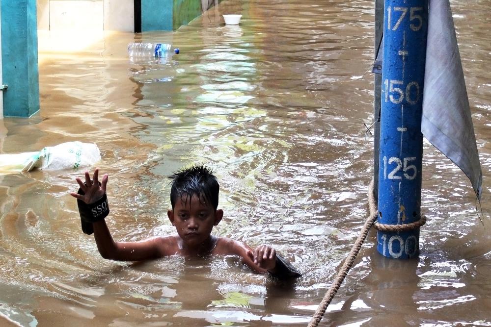 Seorang bocah berjalan melintasi banjir di kawasan Bidara Cina, Jakarta, Senin (10/10/2022). Badan Penanggulangan Bencana Daerah (BPBD) DKI Jakarta menyebutkan hingga Senin (10/10/2022) pukul 09.00 WIB sebanyak 68 rukun tetangga (RT) terendam banjir akibat luapan Sungai Ciliwung./Antara