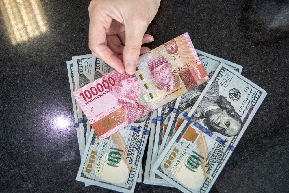 Petugas menunjukan uang pecahan Rupiah dan dolar AS di gerai penukaran mata uang asing VIP (Valuta Inti Prima) Money Changer, Jakarta, Selasa (4/10/2022). /Antara Foto-Muhammad Adimaja