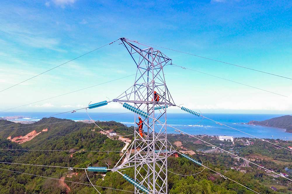 Foto udara pekerja melakukan pemeliharaan transmisi  jaringan kabel Saluran Udara Tegangan Tinggi (SUTT) 150 kV di Desa Kuta, Kecamatan Pujut, Lombok Tengah, NTB, Senin (13/6/2022). ANTARA FOTO/Ahmad Subaidi