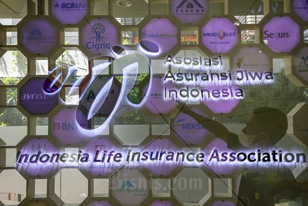 Karyawan beraktivitas di depan logo Asosiasi Asuransi Jiwa Indonesia (AAJI) di Jakarta, Kamis (14/7/2022). Bisnis/Abdurachman