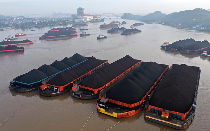 Sejumlah kapal tongkang yang mengangkut batubara berada di Sungai Mahakam di Samarinda, Kalimantan Timur, Rabu (13/10/2021)./Bloomberg-Dimas Ardian