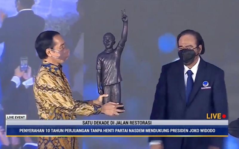 Presiden Joko Widodo menerima patung dari Ketua Umum Partai Nasdem Surya Paloh, yang merupakan simbol 10 tahun dukungan Nasdem tanpa henti kepada Jokowi di acara HUT Partai Nasdem di Jakarta, Kamis, 11 November 2021 / Youtube Nasdem TV