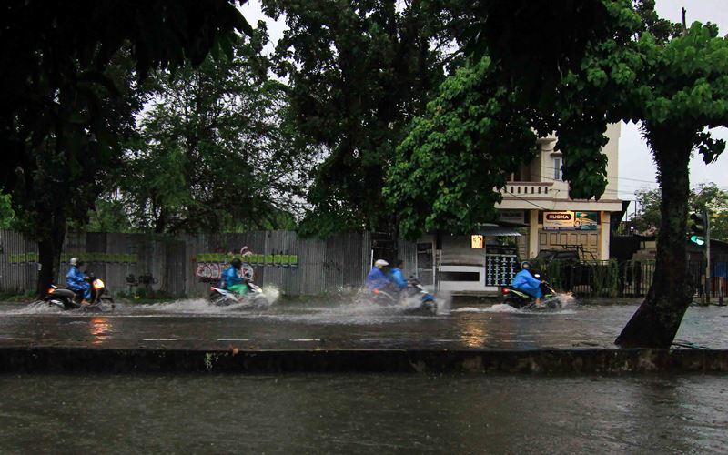 Sejumlah pengendara sepeda motor menerjang banjir yang melanda di Jalan Jati Padang, Sumatra Barat, Jumat (11/11/2022)/Bisnis-Muhammad Noli Hendra