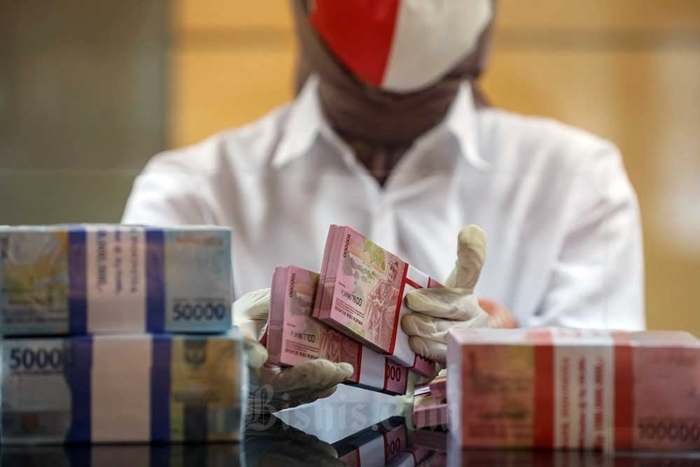 Karyawati menghitung uang rupiah di salah satu kantor cabang PT Bank Negara Indonesia (Persero) Tbk. di Jakarta, Selasa (16/8/2022). /Bisnis-Arief Hermawan P