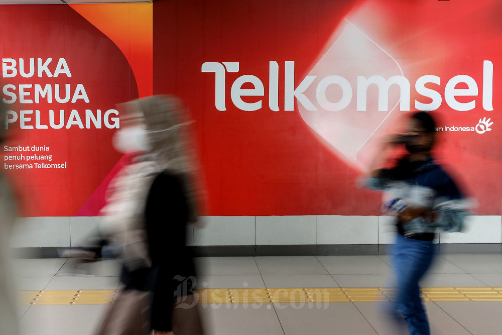 Warga melintasi iklan Telkomsel di Jakarta, Selasa (11/10/2022). Bisnis/Eusebio Chrysnamurti
