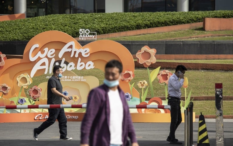 Pejalan kaki melewati kantor pusat Alibaba Group Holding Ltd. di Hangzhou, China, Sabtu (8/5/2021)./Bloomberg-Qilai Shen