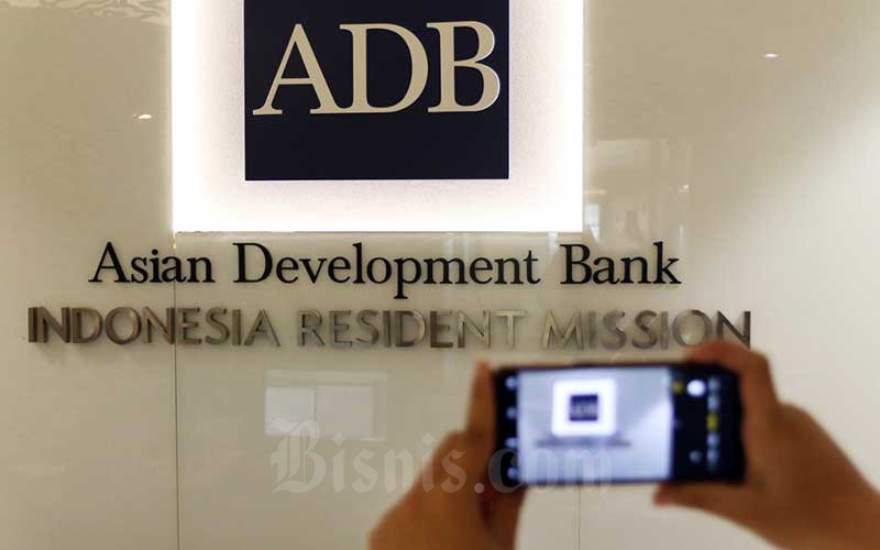 Karyawan memotret logo Asian Development Bank Indonesia di Jakarta, Rabu (8/4/2020). Bisnis/Eusebio Chrysnamurti