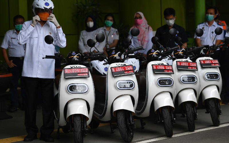 Menteri Perhubungan Budi Karya Sumadi (kiri) bersiap mengendarai motor listrik saat diluncurkan sebagai kendaraan dinas Kementerian Perhubungan di Stasiun Gambir, Jakarta, Rabu (16/12/2020). /ANTARA FOTO