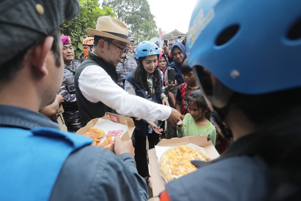 Ridwan Kamil membagikan piza kepada anak-anak yang mengungsi di tenda posko. Anak-anak terlihat bahagia dan antusias saat menerima potongan piza dari Kang Emil.