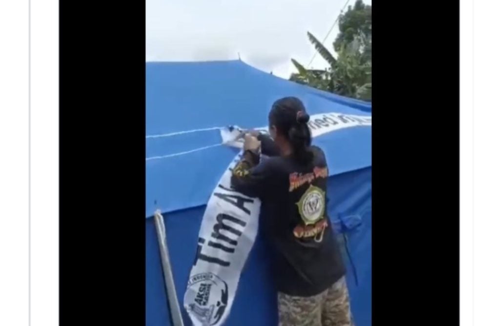 Seorang pria terekam  video mencabut tenda bantuan dari gereja saat gempa Cianjur./Twitter