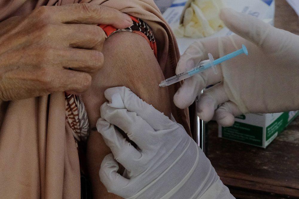 Petugas kesehatan menyuntikkan vaksin dosis ketiga kepada warga di Denpasar, Bali, Selasa (14/6/2022). Dinas Kesehatan Provinsi Bali mengimbau masyarakat untuk mengikuti program vaksinasi Covid-19 dosis ketiga atau penguat (booster) sebagai antisipasi penyebaran Covid-19 subvarian Omicron BA.4 dan BA.5. ANTARA FOTO/Nyoman Hendra Wibowo/rwa.