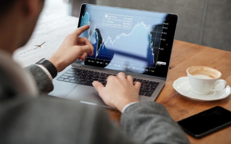 Ilustrasi investor menganalisis pergerakan saham melalui laptop/Freepik.com