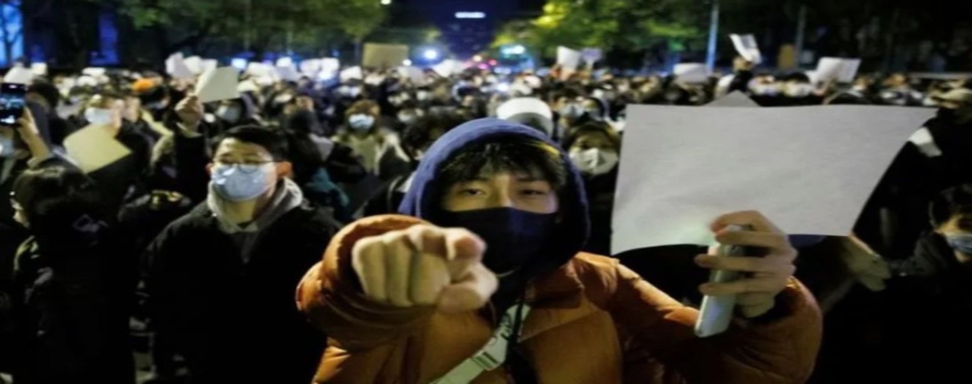 Orang-orang memegang lembaran kertas putih sebagai protes atas pembatasan Covid-19, setelah berjaga bagi para korban kebakaran di Urumqi, di Beijing, China, 27 November 2022. - Antara