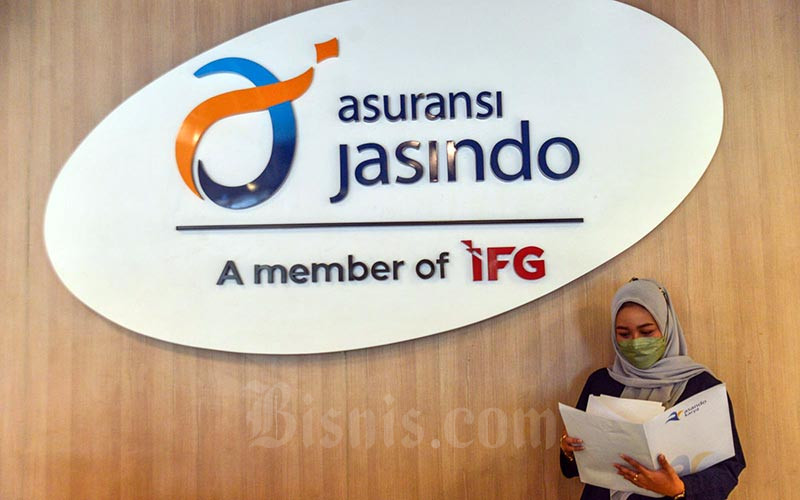 Karyawan beraktivitas di dekat logo PT Asuransi Jasa Indonesia di Jakarta, Rabu (12/1/2022). Bisnis/Fanny Kusumawardhani