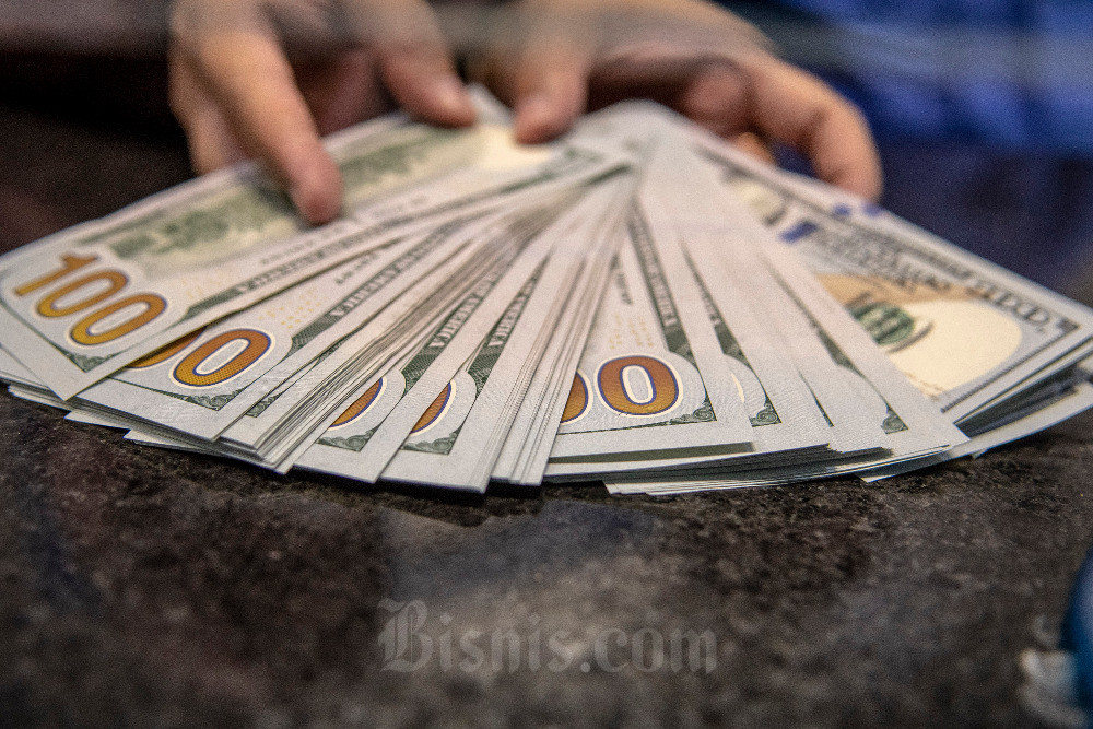 Petugas menunjukan uang pecahan dolar AS di gerai penukaran mata uang asing VIP (Valuta Inti Prima) Money Changer, Jakarta, Selasa (4/10/2022). ANTARA FOTO/Muhammad Adimajarn