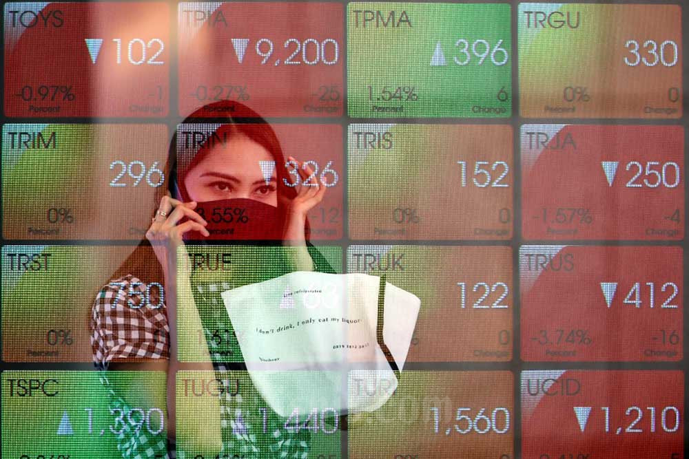 Karyawan melintasi papan elektronik yang menampilkan pergerakan Indeks Harga Saham Gabungan (IHSG) di Bursa Efek Indonesia, Jakarta, Selasa (9/8/2022). Bisnis/Eusebio Chrysnamurti