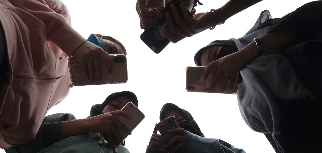 Sejumlah remaja menggunakan ponsel saat berkomunikasi di Medan, Sumatera Utara, Jumat (17/4/2020)./ANTARA FOTO-Septianda Perdana