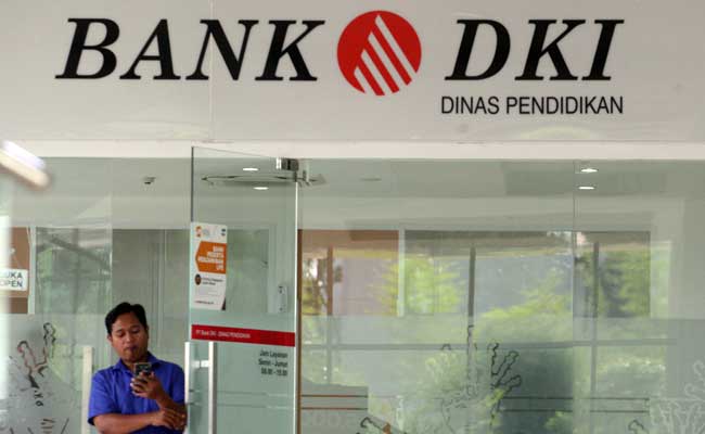 Warga melintas didekat logo bank DKI di Jakarta. Bisnis/Dedi Gunawan