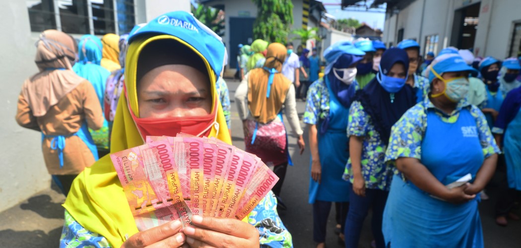 Ilustrasi - Pekerja pabrik rokok PT Djarum di Kudus, Jawa Tengah menunjukkan uang Tunjangan Hari Raya (THR) 2020. Djarum adalah sumber kekayaan awal Hartono bersaudara. Antara - Yusuf Nugroho.