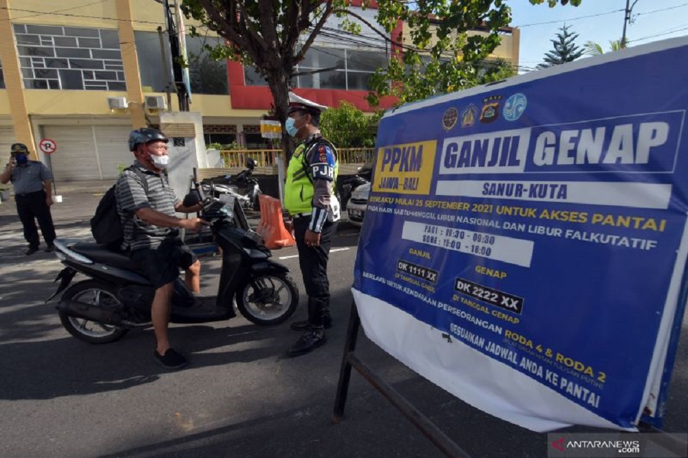 Polisi meminta pengendara sepeda motor dengan plat nomor ganjil untuk putar balik saat penerapan ganjil genap dalam Pemberlakuan Pembatasan Kegiatan Masyarakat (PPKM) level 3 di pintu masuk Pantai Bangsal Sanur, Denpasar, Bali, Sabtu (2/10/2021). ANTARA FOTO/Nyoman Hendra Wibowo/pras