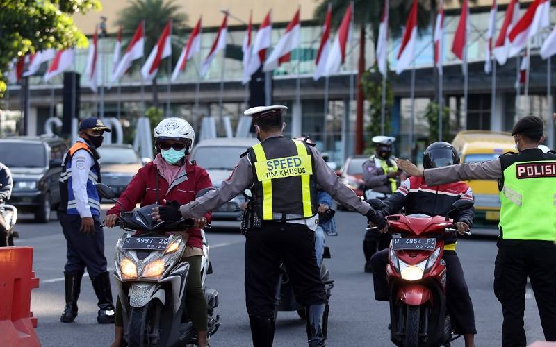 Petugas meminta kendaraan untuk berputar balik karena tidak berkepentingan saat ingin memasuki Kota Surabaya di Bundaran Waru, Surabaya, Jawa Timur, Senin (2/8/2021)./Antara-Umarul Faruq.