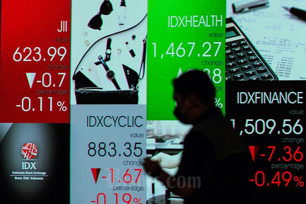 Karywan melintas di dekat layar pergerakan indeks harga saham gabungan (IHSG) di Bursa Efek Indonesia, Jakarta, Selasa (20/9/2022). Bisnis/Fanny Kusumawardhani