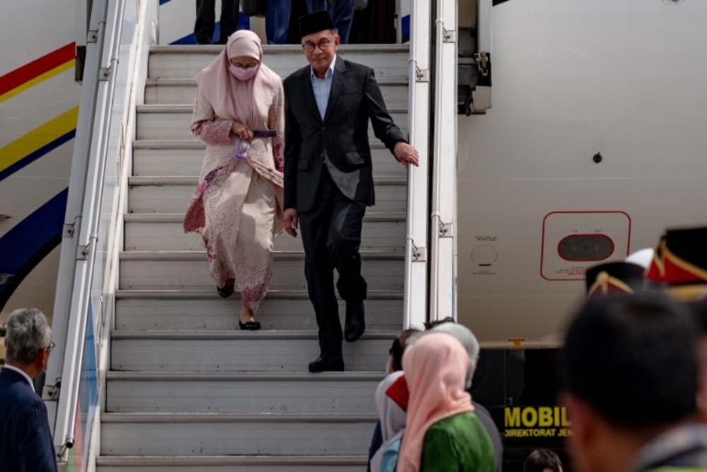 Perdana Menteri (PM) Malaysia Anwar Ibrahim tiba di Jakarta bersama istrinya, Wan Azizah Wan Ismail pada Minggu (8/1/2023). Saat tiba di Indonesia, dia mengenakan songkok./Twitter @anwaribrahim
