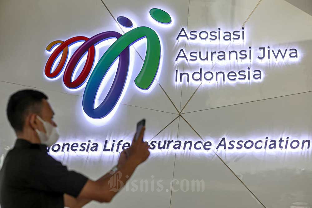 Karyawan beraktivitas di depan logo Asosiasi Asuransi Jiwa Indonesia (AAJI) di Jakarta, Kamis (14/7/2022)./Bisnis-Abdurachman