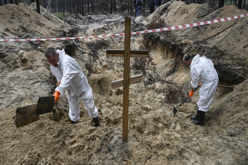 Petugas forensik menggali kuburan massal tak dikenal di kota Izyum, Ukraina  Timur/The Moscow Times