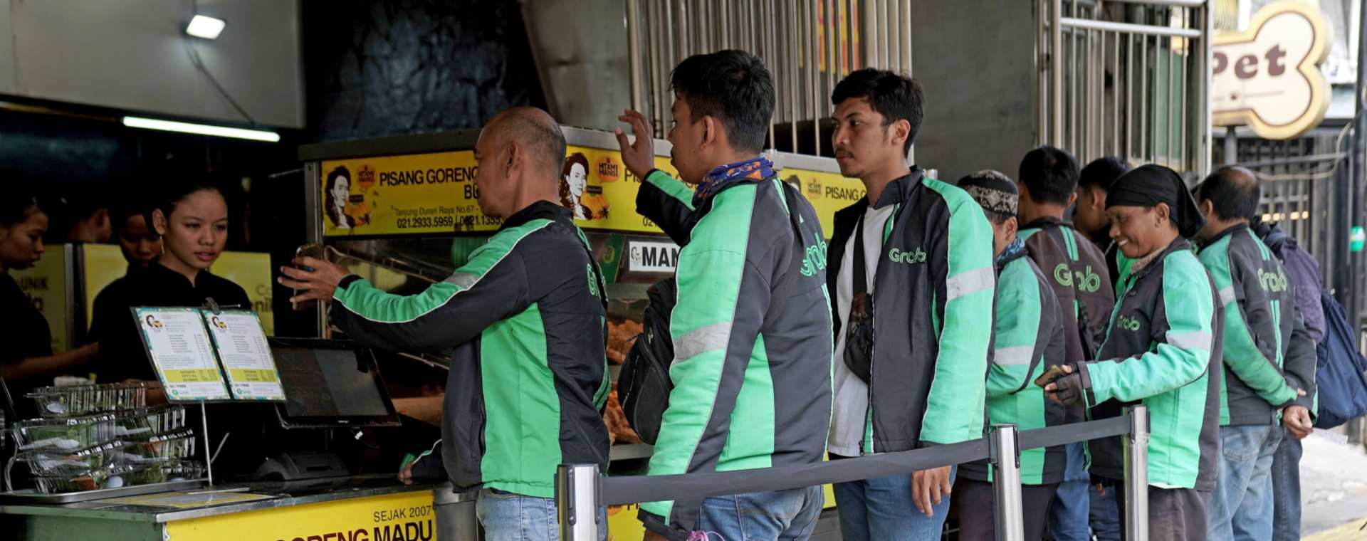 Driver GrabFood dari Grab Holdings Inc. berbaris untuk mengambil pesanan di toko Pisang Goreng Bu Nanik di Jakarta, Indonesia, pada Senin, 15 Juli 2019.  - Bloomberg