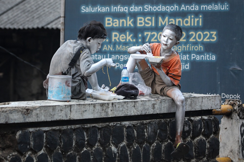 ALOKASI ANGGARAN PERLINSOS UNTUK RAKYAT MISKIN. Dua orang anak manusia silver menyantap makanan di kawasan Depok, Jawa Barat, Selasa (23/8/2022). JIBI/Bisnis/Arief Hermawan P. 