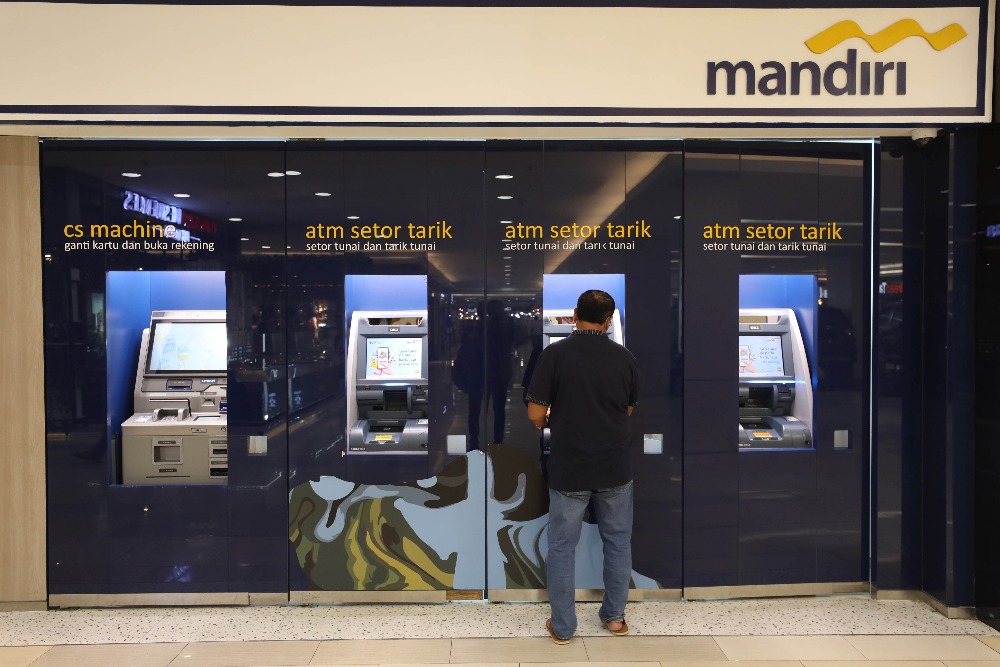Nasabah melakukan transaksi melalui mesin anjungan tunai mandiri (ATM) milik Bank Mandiri di Jakarta, Rabu (4/1/2023). /Bisnis-Eusebio Chrysnamurti