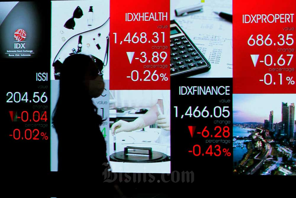 Karyawan melintas di dekat layar pergerakan indeks harga saham gabungan (IHS) di Bursa Efek Indonesia, Jakarta, Selasa (11/10/2022). Bisnis/Fanny Kusumawardhani