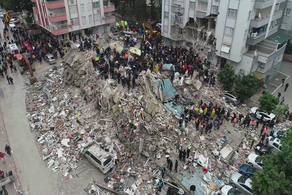Gempa Turki: 500 WNI Terdampak, 3 Orang Luka-luka. Orang-orang di antara puing-puing setelah gempa bumi di Adana, Turki 6 Februari 2023. Kantor Berita Ihlas (IHA) via REUTERS