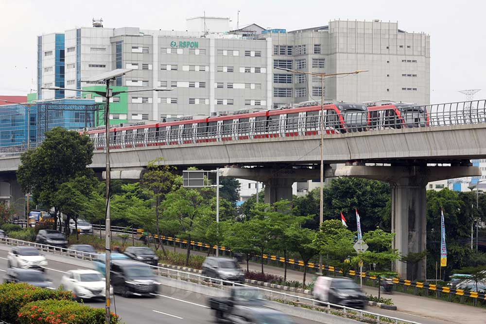 Kendaraan melintas di dekat rangkaian gerbong kereta Light Rail Transit (LRT) di Jakarta, Minggu (2/10/2022). Bisnis/Suselo Jati