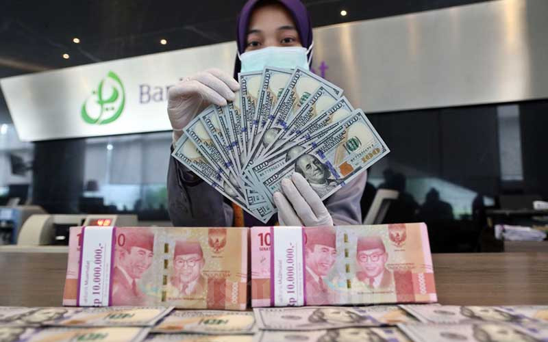 Karyawan menunjukan dolar AS di Jakarta, Rabu (3/3/2021). Bisnis/Eusebio Chrysnamurti