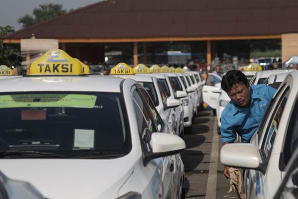 Pengemudi taksi Express menunggu penumpang di pool taksi Bandara Soekarno-Hatta, di Tangerang, Banten. PT Rajawali Corpora milik konglomerat Peter Sondakh melepas kepemilikan sahamnya di PT Ekspress Trasindo Utama Tbk. (TAXI). /JIBI-Felix Jody Kinarwan 