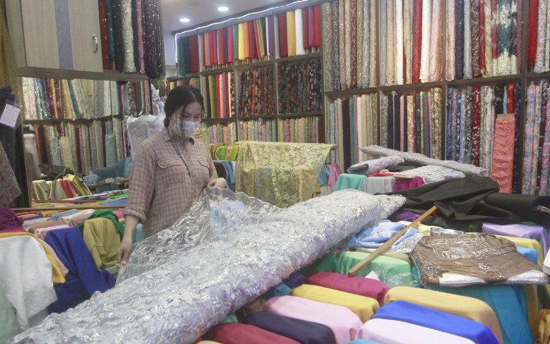 Pedagang merapikan kain di salah satu gerai di Pasar Tanah Abang, Jakarta, Selasa (8/12/2020). /Bisnis.com-Himawan L Nugraha
