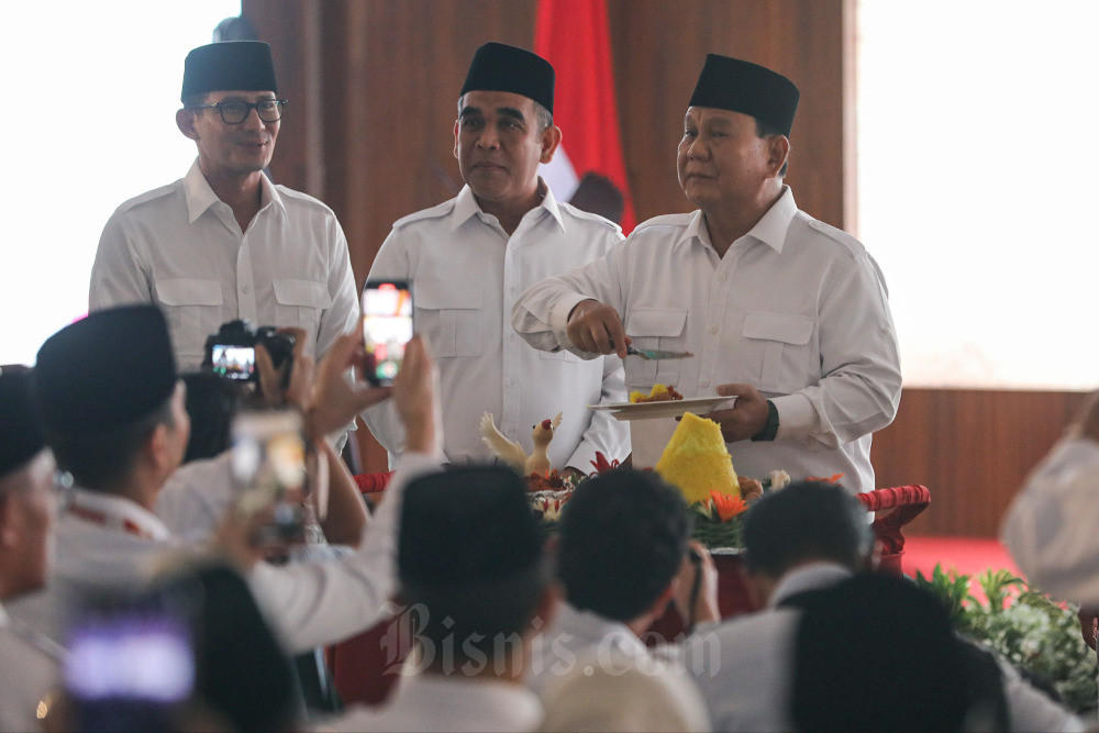 Ketua Umum Partai Gerindra Prabowo Subianto (kanan) disaksikan Wakil Ketua Dewan Pembina Sandiaga Uno (kiri) dan Sekretatis Jenderal Ahmad Muzani memotong tumpeng saat peringatan Hari Ulang Tahun (HUT) ke-15 Partai Gerindra di Jakarta, Senin (6/2/2023). Bisnis/Arief Hermawan P