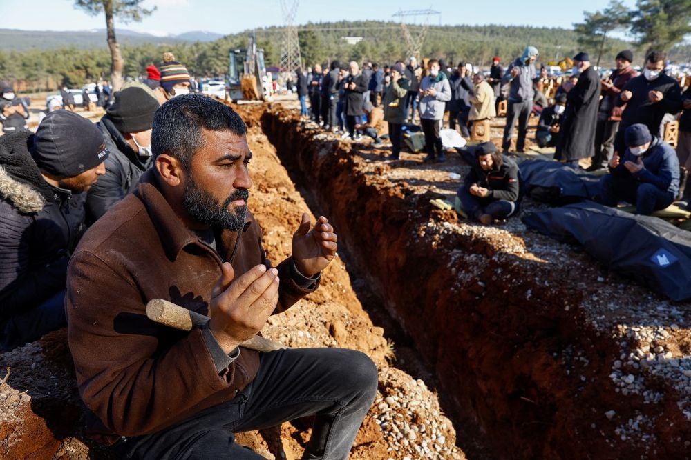 Orang-orang berdoa saat mereka bersiap untuk menguburkan korban gempa mematikan di pemakaman di Kahramanmaras, Turki pada 9 Februari 2023. REUTERS/Suhaib Salem