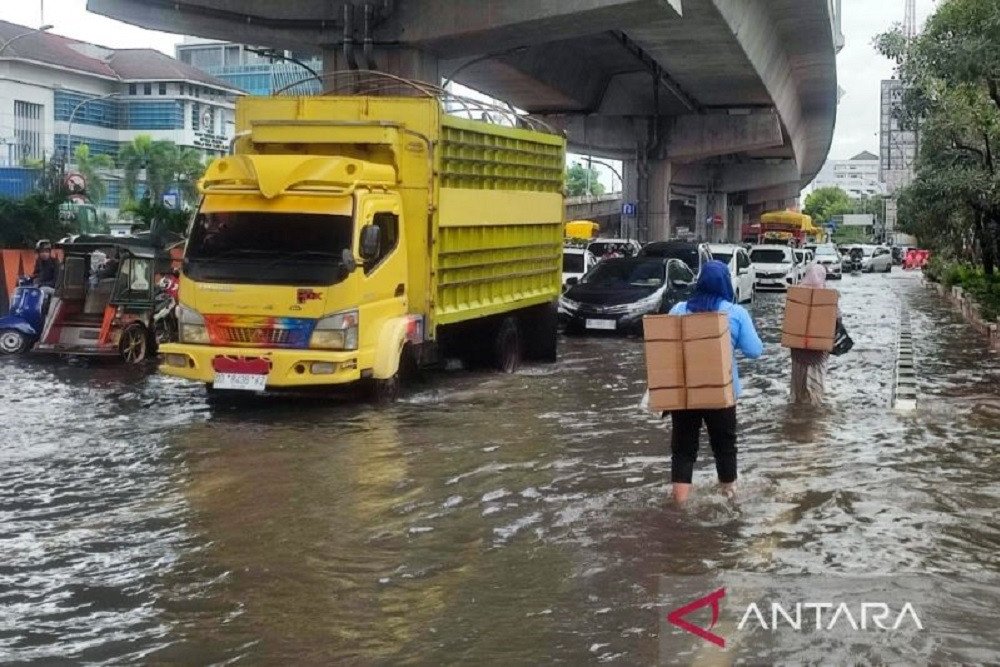 Dua pejalan kaki menerobos banjir yang menggenangi Jalan Andi Pangeran Pettarani, Makassar, Sulawesi Selatan./ANTARA-Darwin Fatir.