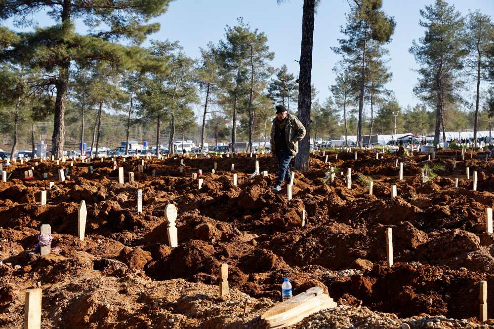 Seorang pria berdiri di antara kuburan para korban di Kahramanmaras, Turki 9 Februari 2023. REUTERS/Suhaib Salem