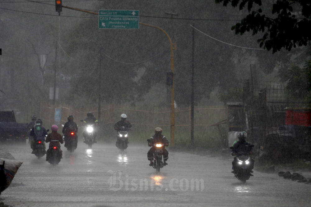 Sejumlah pengguna kendaraan menembus hujan deras di kawasan Baleendah, Kabupaten Bandung, Jawa Barat. Bisnis/Rachman
