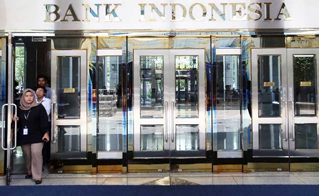 Karyawan melintas didekat logo Bank Indonesia di Jakarta, Senin (30/12/2019). Bisnis/Abdullah Azzam
